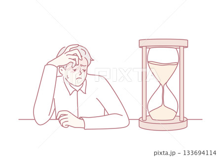 Tired businessman looking at hourglass 133694114