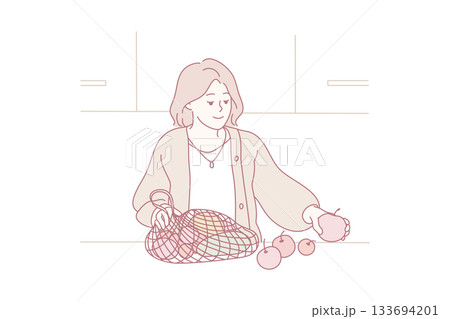 environmentally conscious woman tidying organic apples from reusable shopping bag in modern kitchen environmentally conscious woman tidying organic apples from reusable shopping bag in modern kitchen 133694201