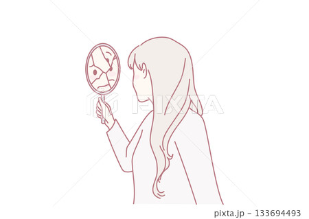 Woman looking in broken mirror 133694493