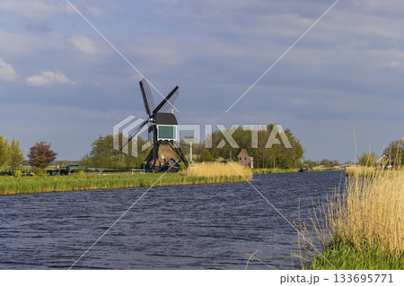 Windmill standing by canal in Molenlanden, Netherlands 133695771