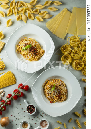 Two bowls of spaghetti bolognese with fresh ingredients 133695781