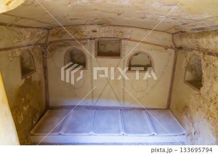 Roman burial chamber interior displaying ancient frescoes in Carmona, SPAIN 133695794