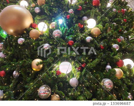 Beautifully decorated christmas tree texture features glowing light and colorful ball ornaments bringing joy to holiday season. Festive set creates perfect backdrop with copyspace for greeting Beautifully decorated christmas tree texture features glowing light and colorful ball ornaments bringing joy to holiday season. Festive set creates perfect backdrop with copyspace for greeting 133696687