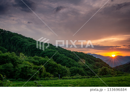 福島県南会津町・初夏の山並みに沈む美しい夕日と緑の風景 133696884