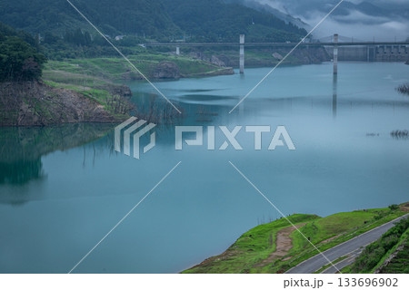 八ッ場ダムを望む朝霧の湖面と静かな山並みの風景（群馬県長野原町） 133696902