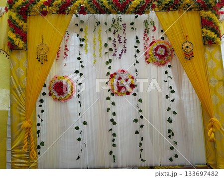 Beautiful wedding stage with plastic leaves and flowers. elegant indian wedding stage decoration background. tent for conference, wedding and party Beautiful wedding stage with plastic leaves and flowers. elegant indian wedding stage decoration background. tent for conference, wedding and party 133697482