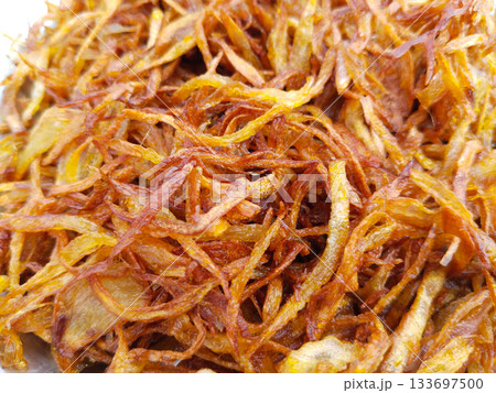 fried red onions, Crispy fried onions in a plate are fried to a golden brown color. roasted onion slices background fried red onions, Crispy fried onions in a plate are fried to a golden brown color. roasted onion slices background 133697500