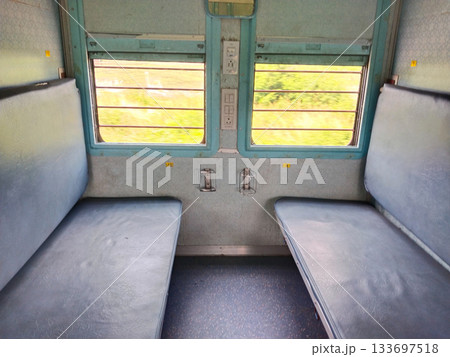 Empty seats, windows and berths inside a second class sleeper compartment in a train run by the Indian Railways. electric sockets for mobile and laptop charging 133697518