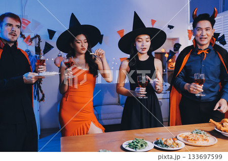 Joyful office Halloween party with coworkers in costumes, celebrating with drinks and laughter, fostering teamwork and festive spirit Joyful office Halloween party with coworkers in costumes, celebrating with drinks and laughter, fostering teamwork and festive spirit 133697599