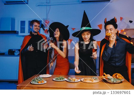 Joyful office Halloween party with coworkers in costumes, celebrating with drinks and laughter, fostering teamwork and festive spirit 133697601