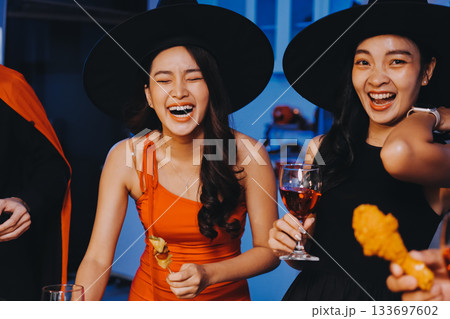 Joyful office Halloween party with coworkers in costumes, celebrating with drinks and laughter, fostering teamwork and festive spirit 133697602