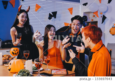 Joyful office Halloween party with coworkers in costumes, celebrating with drinks and laughter, fostering teamwork and festive spirit 133697643