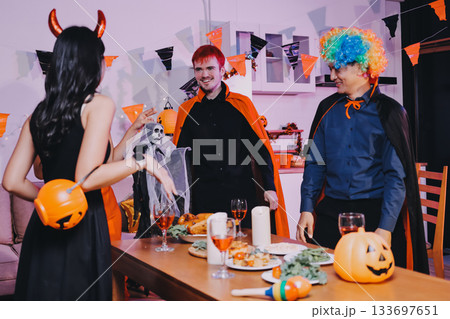 Joyful office Halloween party with coworkers in costumes, celebrating with drinks and laughter, fostering teamwork and festive spirit Joyful office Halloween party with coworkers in costumes, celebrating with drinks and laughter, fostering teamwork and festive spirit 133697651