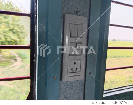 close up portrait of electrical socket and iron window found on trains in india close up portrait of electrical socket and iron window found on trains in india 133697769