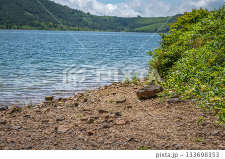 野反湖の湖畔に広がる夏の透明な湖水と砂利浜の風景（群馬県） 133698353