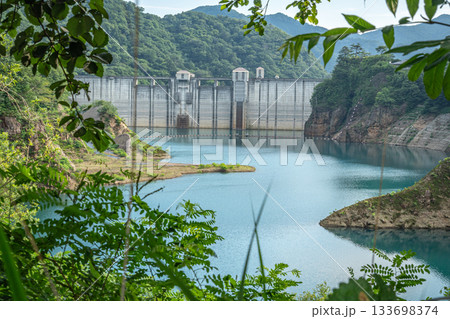 夏の奥四万湖と四万川ダムを囲む深緑と静かな水面の風景 133698374