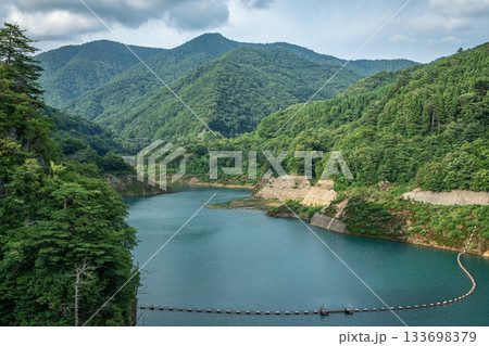 群馬県中之条町・四万川ダム湖と夏の緑深い山々の風景 群馬県中之条町・四万川ダム湖と夏の緑深い山々の風景 133698379