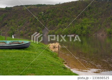 Rowboat on grassy riverbank with forest view at Nova Zivohost 133698525