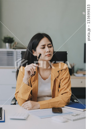 Business woman using calculator for do math finance on wooden desk in office and business working background, tax, accounting, statistics and analytic research concept. Business woman using calculator for do math finance on wooden desk in office and business working background, tax, accounting, statistics and analytic research concept. 133699833