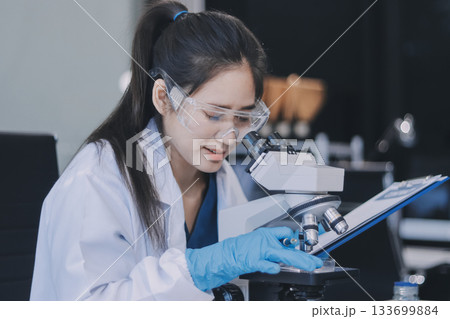 Portrait, science and happy woman on laptop in lab to research chemistry, test or innovation. Microscope, scientist and face of medical doctor in goggles for microbiology, healthcare or pharma study 133699884