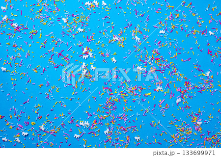 Colorful holiday confetti on bright blue. Happy New Year and Christmas designs. Colorful holiday confetti on bright blue. Happy New Year and Christmas designs. 133699971