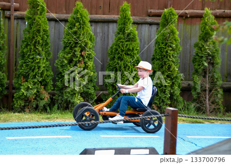 boy driving quad bike, four wheel cycle car, spring brightly morning, sunny day. High quality photo boy driving quad bike, four wheel cycle car, spring brightly morning, sunny day. High quality photo 133700796