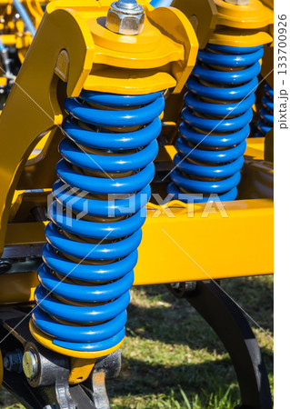 Steel blue spring as part of heavy agricultural, industrial machine. Technology 133700926