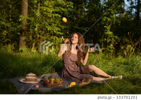 Cheerful woman in casual attire enjoying sunny picnic moment 133701201