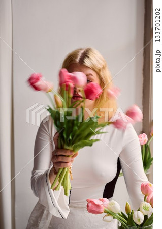Caucasian woman interacting with colorful blooming flowers 133701202