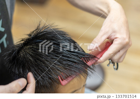 髪に櫛を入れる理容師の手 髪に櫛を入れる理容師の手 133701514