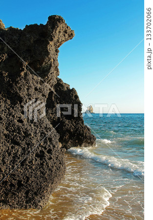 Volcanic cliff in the sea surf on the island of Corfu, Greece. Volcanic cliff in the sea surf on the island of Corfu, Greece. 133702066