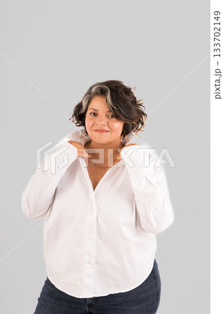 A woman in a white shirt and blue jeans is posing for a picture 133702149