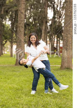 A woman and a little girl are playing in a park A woman and a little girl are playing in a park 133702193