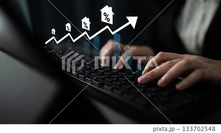 Person Using Keyboard with Graph and House Icons Representing Real Estate Trends, Growth, and Financial Analysis in Dark Environment Gantry Person Using Keyboard with Graph and House Icons Representing Real Estate Trends, Growth, and Financial Analysis in Dark Environment Gantry 133702548