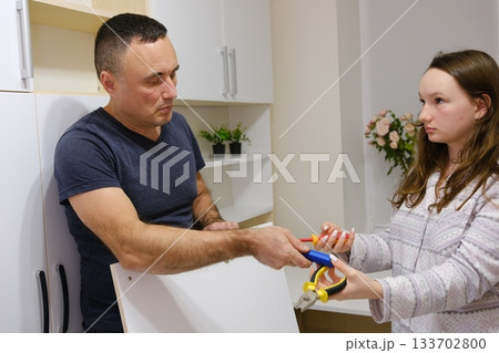 A father repairs a closet door in his daughter's room. Family values: good parent-child relationships. A video set showing the process of repairing a cabinet door A father repairs a closet door in his daughter's room. Family values: good parent-child relationships. A video set showing the process of repairing a cabinet door 133702800