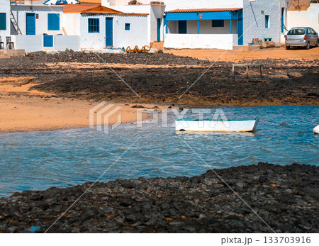 A fishing village with old houses on the Atlantic ocean coast of Fuerteventura island. A fishing village with old houses on the Atlantic ocean coast of Fuerteventura island. 133703916