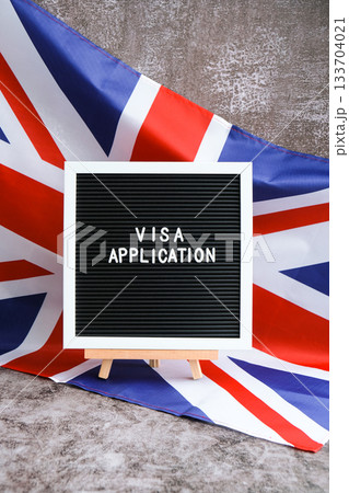 Letter board text VISA APPLICATION National symbol of Great Britain. British wave the UK silky flag background. Temporary work permit employment migration 133704021