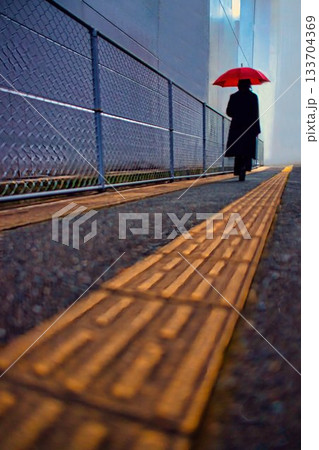 雨の日の歩道を歩く日傘の女性 133704369
