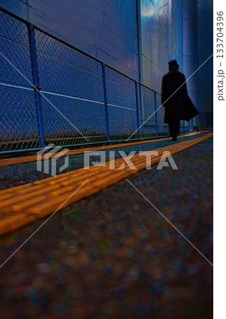 夕日の裏路地を歩く黒いコートの女性 夕日の裏路地を歩く黒いコートの女性 133704396
