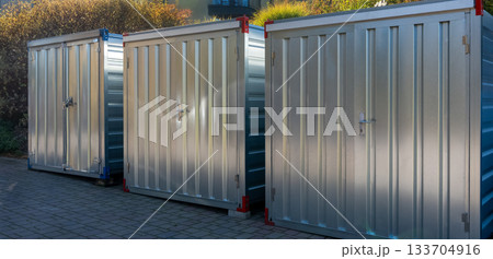 Row of metal storage containers outdoors in sunlight Row of metal storage containers outdoors in sunlight 133704916