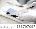 キッチンで包丁研ぎの手元 133707097