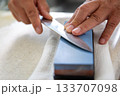 キッチンで包丁研ぎの男性の手元 133707098