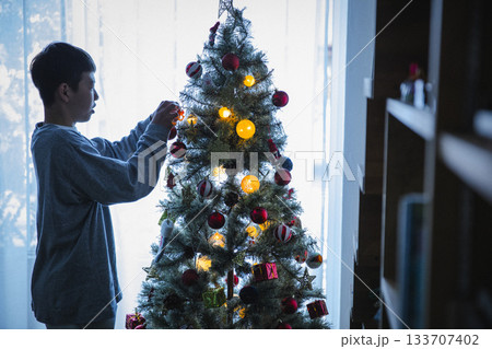自宅のクリスマスツリーの準備をする男の子 133707402