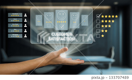 Hand Reaching Out Displaying Customer Satisfaction Feedback Ratings with Smiley Faces and Stars in Modern Office Environment. Auvana 133707489