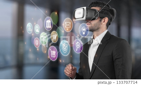 Businessman Using Virtual Reality Headset with Digital Icons Representing Technology, Finance, Communication, and Shopping in Modern Office Environment. Raster Businessman Using Virtual Reality Headset with Digital Icons Representing Technology, Finance, Communication, and Shopping in Modern Office Environment. Raster 133707714
