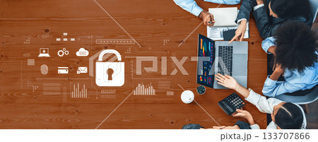 Business Team Meeting for Cybersecurity Strategy with Digital Security Icons and Laptop on a Wooden Table for Corporate Planning Trope 133707866