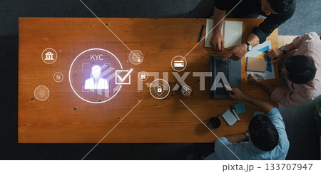 Collaboration of professionals analyzing KYC process in modern workspace with digital icons showcasing data security and verification standards Trope Collaboration of professionals analyzing KYC process in modern workspace with digital icons showcasing data security and verification standards Trope 133707947