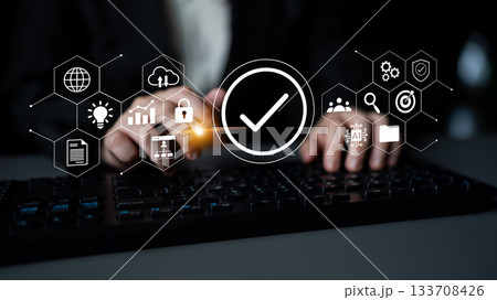 Hands typing on a keyboard with digital icons representing data security, technology, and communication in a modern office environment Gantry 133708426