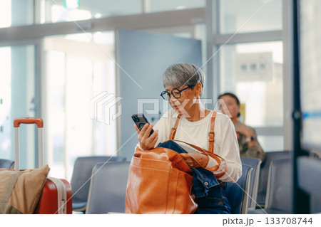 フェリーターミナルで出発を待つシニア女性 133708744