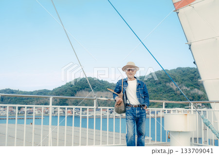 フェリーの甲板で港町を眺めるシニア夫婦の旅行ポートレート 133709041